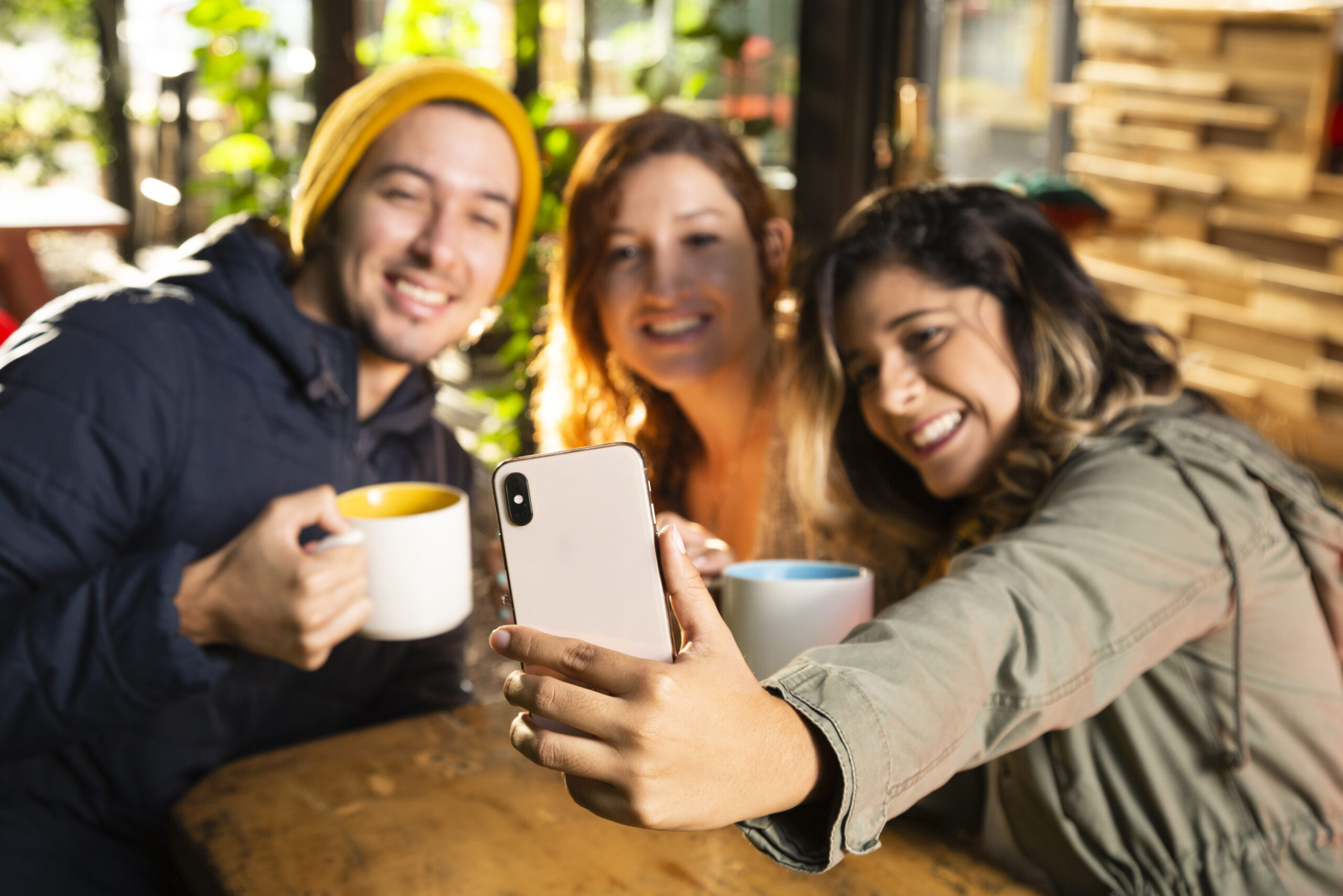 Upswap save money Friends using Upswap app at a local café enjoying summer on a budget