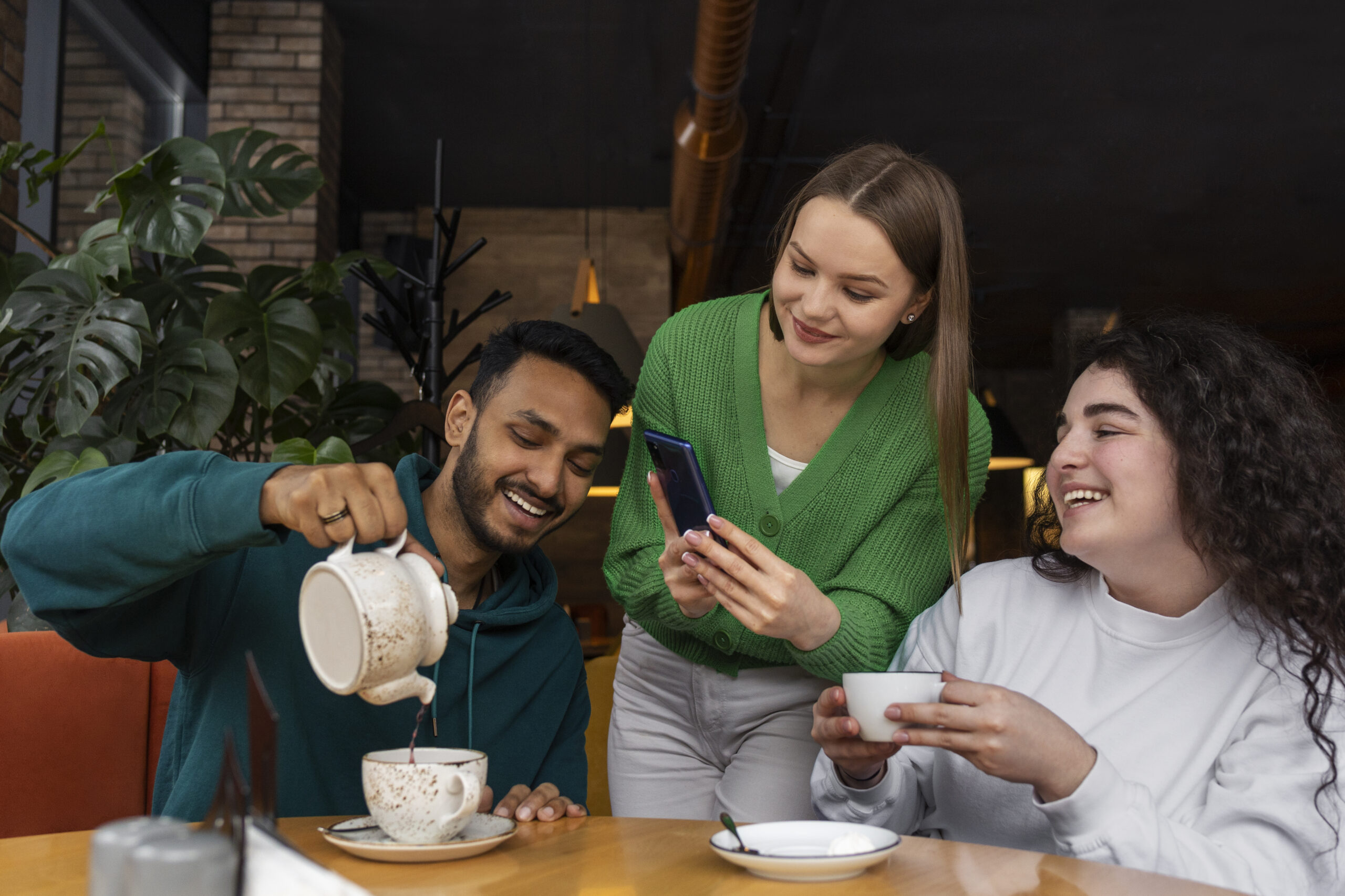 Group of friends laughing and chatting over chai cups