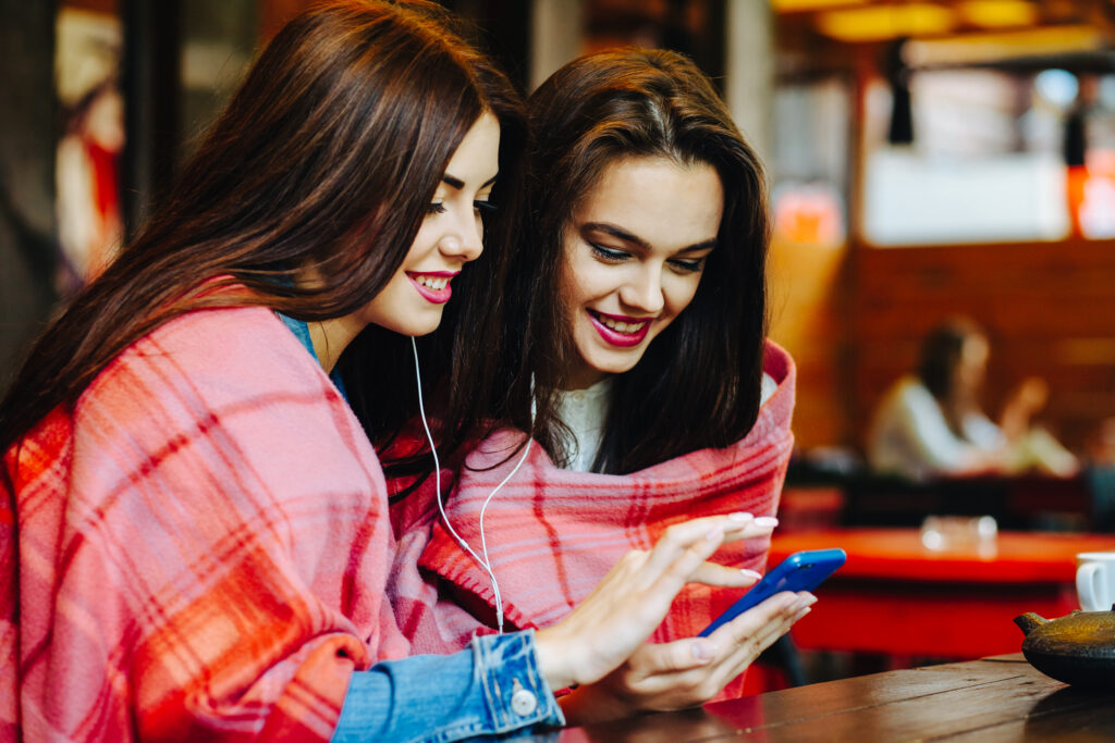 Girl using Upswap app on her phone to save money while shopping with friends.