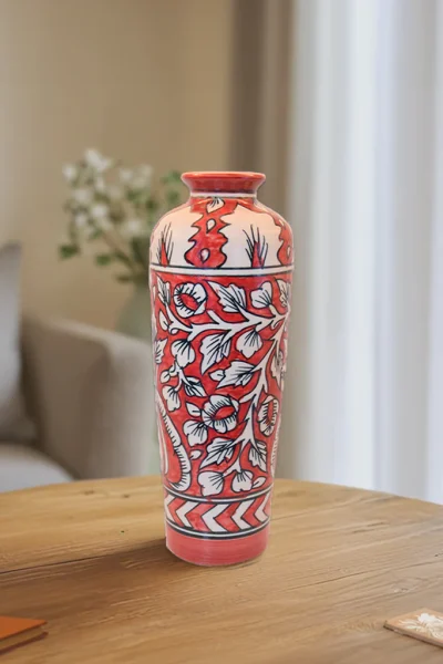 The Crimson Bloom Vase is a true work of art. Its rich red and cream tones, paired with intricate floral patterns, are inspired by timeless traditional Indian designs. Whether placed in a minimalist modern setting or a room filled with vintage décor, this vase stands out beautifully.