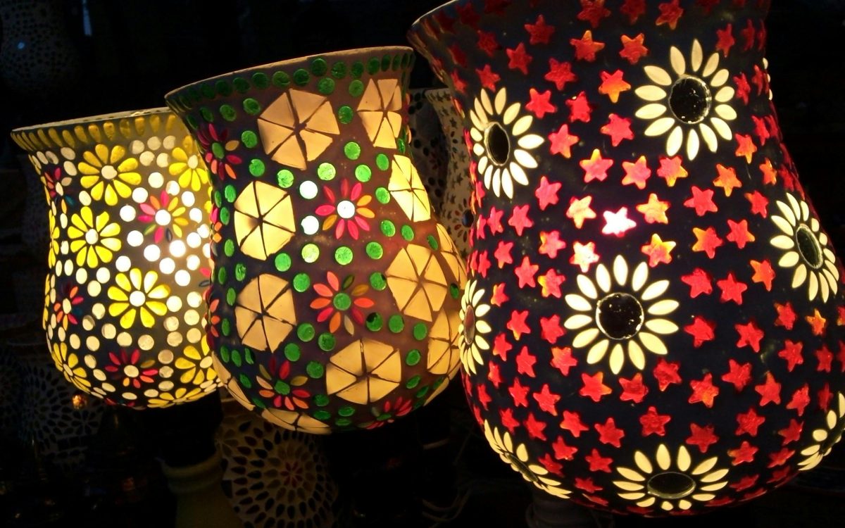 A photo showcasing a variety of beautiful Indian handicrafts, like a woven rug, a metal lamp, and a colorful painting